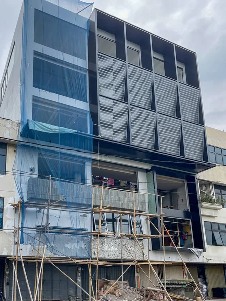 Glass facade of a modern building with a geometric design.
