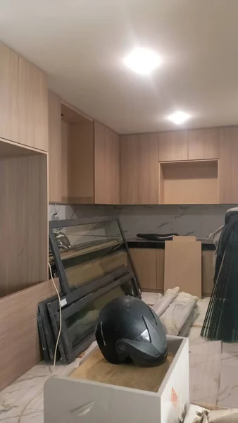 Modern kitchen interior with light brown wooden cabinets and a black countertop.