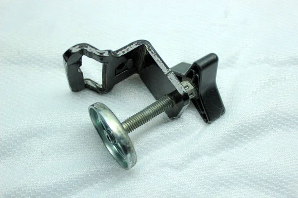 Siyah ve gri, evrensel taşınabilir demir ayaklı, bacakları ve kıskacı olan, beyaz arka plana odaklanmış.