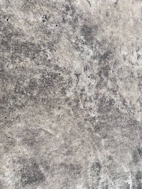 Kirli, çatlamış, koyu gri beton bir yüzeyin pürüzlü yakın çekim dokusu aşınmayı ve düzensiz bir deseni gösteriyor..