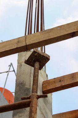 Yeni dökülmüş beton kiriş için ahşap döşemeyi destekleyen paslı çelik pervanenin ayrıntıları..