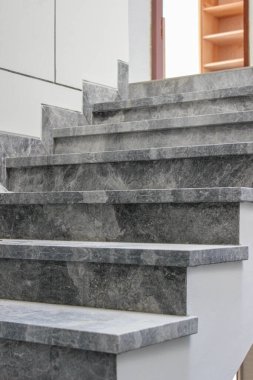 Modern bir evin merdivenlerinde ince beyaz damarları olan koyu gri mermer bir katman kurulmuş..