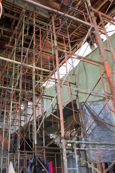 Çok renkli çelik iskelet iskeleti ve ahşap döşeme destekli beton döşeme döşemeleri çok katlı bir inşaat sahasında..