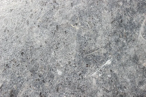 Gri-siyah granit taş yüzeyinin pürüzlü dokusu, açık ve koyu mineral parçacıkları, yer döşemeleri veya tezgahlar için uygundur..