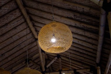 Jakarta, Endonezya - 01 Ocak 2026: Bambu tavanda örülmüş kaktan ve Omah Badok restoranında gedheg dokuması yapılan dekoratif top asılı lambası.