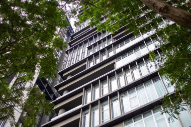 Jakarta, Endonezya - 09 Ocak 2026: Lüks apartman dairesi yemyeşil ağaçların arkasından görüldü.