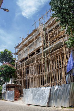 Jakarta, Endonezya - 09 Ocak 2026: Yol kenarındaki geleneksel bambu yapı iskelelerini kullanarak yüksek binalar inşa etme projesi.