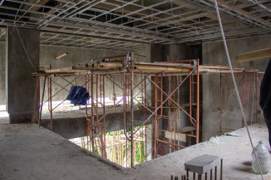 İç yapı yenilenme aşamasında metal tavan iskeleti kurulumunu ve odanın ortasında demir iskelenin kullanımını gösteriyor..