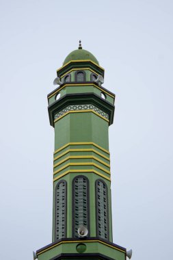 Jakarta, Endonezya - 18 Ocak 2026: Gökyüzüne bakan toa hoparlörlü yeşil Jami Al-Ittihadiyah minaresi.