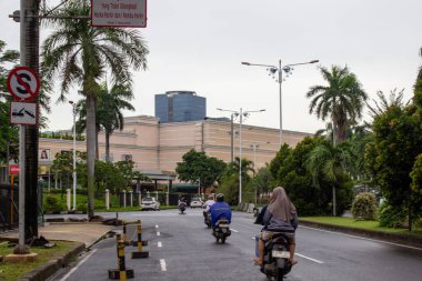 Jakarta, Endonezya - 18 Ocak 2026: Arka planda bulutlu Kembangan bölgesinde yüksek binalarla otoyoldan geçen motosiklet trafiği.