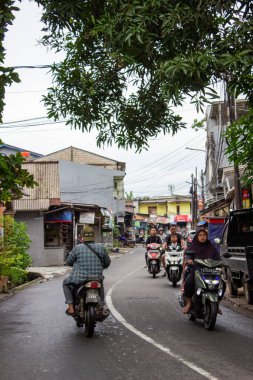 Jakarta, Endonezya - 18 Ocak 2026: Bojong Raya caddesinden geçen bir dizi motosikletli çerçeve üzerindeki mango ağacı dallarıyla süslenmiş.