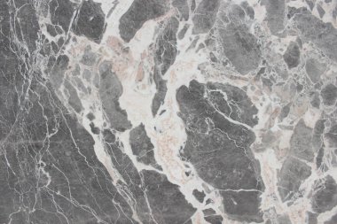 Gri kaya parçaları ve kalın, dinamik beyaz damarlar içeren Breccia Grigio mermer dokusu.
