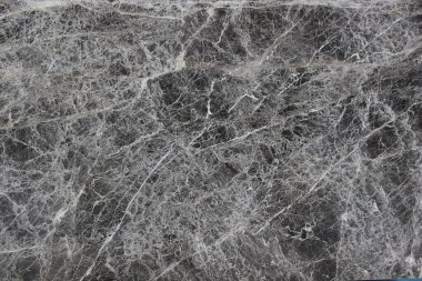 Grigio Carnico mermer dokusu koyu gri tonlar ve dramatik, rastgele beyaz damarlar kesişiyor..