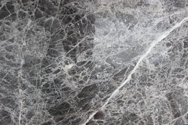 İran 'dan Pietra gri mermer dokusu, koyu gri arka planda ince beyaz damarlar kesişiyor..