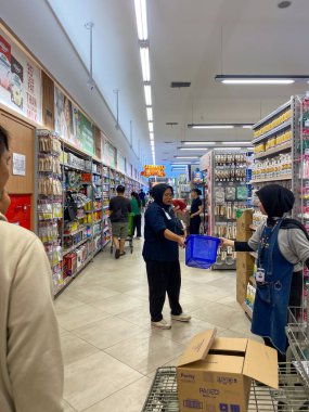 Jakarta, Endonezya - Şubat 08 2026: Jakarta 'daki ev ürünleri reyonunda tesettürlü GrandLucky süpermarket çalışanları.