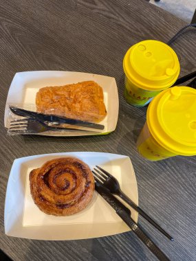 Jakarta, Endonezya - Şubat 08 2026: İçinde tarçınlı çörek ve çikolatalı kruvasan bulunan iki adet sarı kapaklı Flash Coffee.