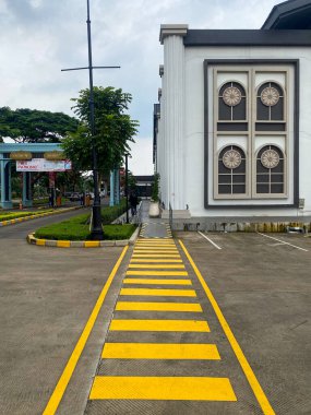 Jakarta, Endonezya - 08 Şubat 2026: Sarı işaretli yaya yolu Grand Lucky Lake City ticari bölgesinde modern klasik bir binaya çıkıyor.