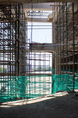 Jakarta, Endonezya - 16 Mart 2026: Yeşil güvenlik ağlı yüksek katlı bir inşaat projesinin çelik yapı iskelesi.