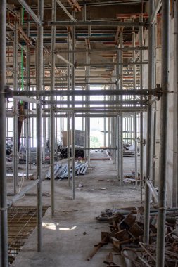 Jakarta, Endonezya - 16 Mart 2026: Cakarta 'da metal yapı iskelesi ve dağınık inşaat malzemeleri bulunan bir bina koridorunun görüntüsü