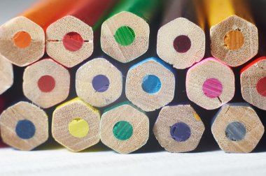 Beyaz masa üzerinde renkli kalemler yığını. 