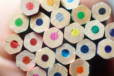 Beyaz masa üzerinde renkli kalemler yığını. 