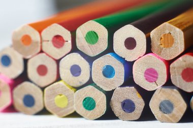 Beyaz masa üzerinde renkli kalemler yığını. 