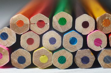 Beyaz masa üzerinde renkli kalemler yığını. 