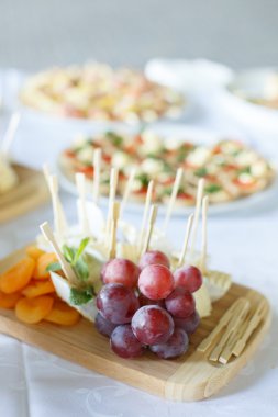 Bir restoranda ahşap plaka üzerinde üzüm ile Peynir tabağı