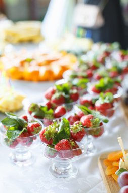 Beyaz masada bir cam kase çilek