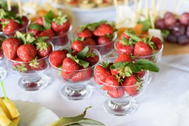 Beyaz masada bir cam kase çilek