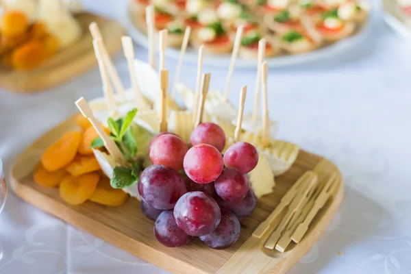 Placa de Queso con uva en plato de madera en un restaurante — Foto de Stock