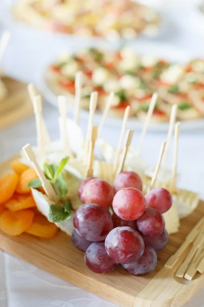 Placa de Queso con uva en plato de madera en un restaurante — Foto de Stock