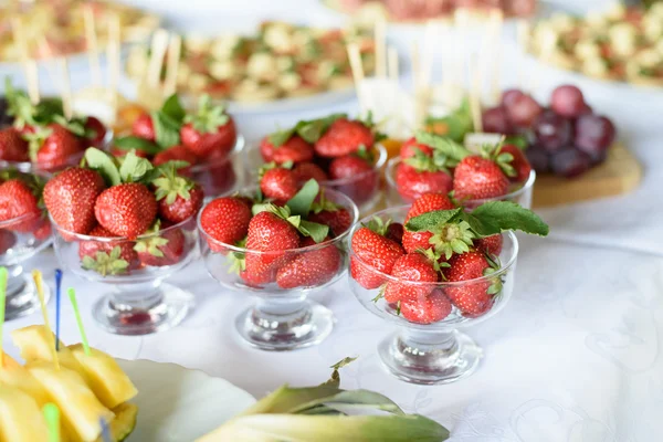 Aardbeien in een glazen kom op de witte tafel — Stockfoto