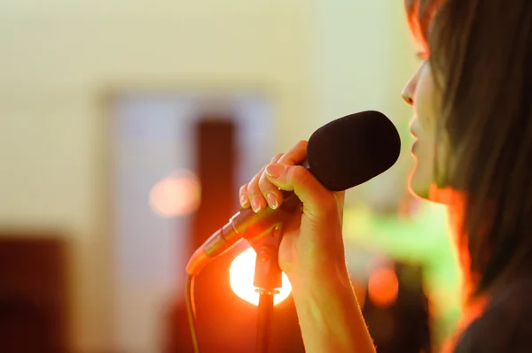 Uma mulher que assina o foco de concerto ao vivo no microfone — Fotografia de Stock