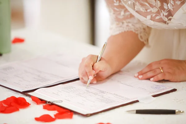 Noiva assina certidão de casamento com uma caneta — Fotografia de Stock