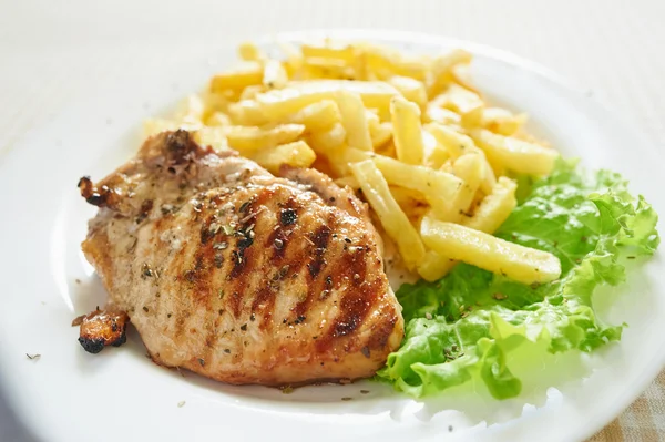 Куриный стейк с картошкой фри и салатом — стоковое фото