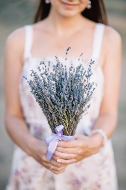 Gelin elinde bir buket çiçek tutuyor.