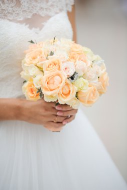 Gelin elinde bir buket çiçek tutuyor.
