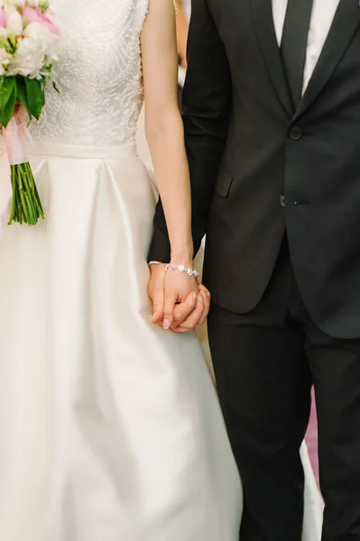 Gelin ve damat el ele tutuşuyorlar.