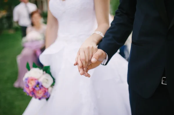Bride and groom holding hands — Stock Photo, Image