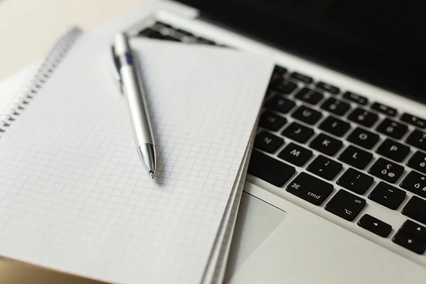 Laptop mit Notizblock, Stift auf Elfenbeintisch — Stockfoto