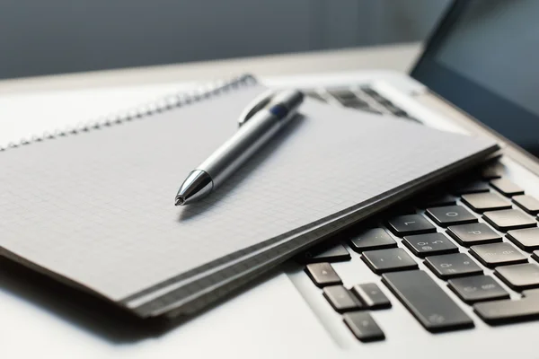 Laptop mit Notizblock, Stift auf Elfenbeintisch — Stockfoto