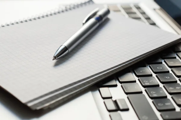 Laptop mit Notizblock, Stift auf Elfenbeintisch — Stockfoto