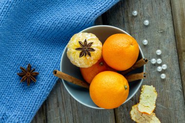 Ahşap bir arka planda mandalina, anason ve tarçın.