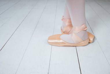 Ayağındaki puanlı ayakkabılar bej renginde beyaz arkaplanda