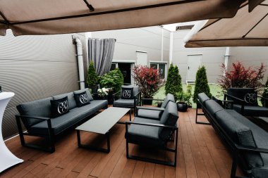 Şemsiyeli teras, kanepe, koltuk, masa.