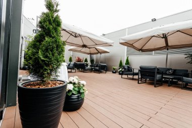 Şemsiyeli teras, kanepe, koltuk, masa.