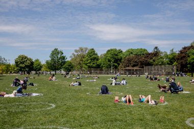 İnsanlar Trinity Bellwood Parkı 'nda takılıyor,' Sosyal Mesafe Çemberleri 'nde oturuyor. Dairelerin çapı 2,5 metre ve COVID-19 salgını sırasında parka gidenler arasındaki fiziksel mesafeyi sağlamak için aralarında 3 metre mesafe bırakılıyor..