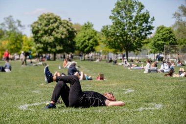 İnsanlar Trinity Bellwood Parkı 'nda takılıyor,' Sosyal Mesafe Çemberleri 'nde oturuyor. Dairelerin çapı 2,5 metre ve COVID-19 salgını sırasında parka gidenler arasındaki fiziksel mesafeyi sağlamak için aralarında 3 metre mesafe bırakılıyor..