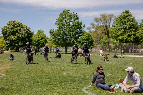 경찰은 모두가 사회적 거리의 규칙을 지키도록 트리니티 공원을 순찰하고 사람들은 — 스톡 사진